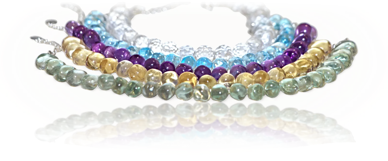 The five bracelets stacked together, Wood, Earth, Fire, Water and Metal, reflected on a glossy surface